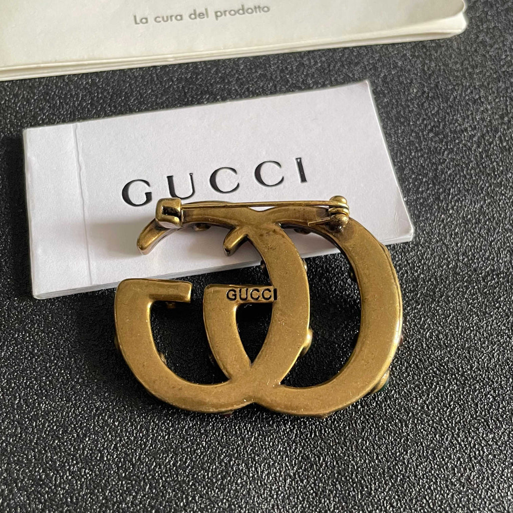 GUCCI 26S INTERLOCKING G MULTICOLOR GEM LOGO BROOCH IN ANTIQUE GOLD TONE METAL 625634