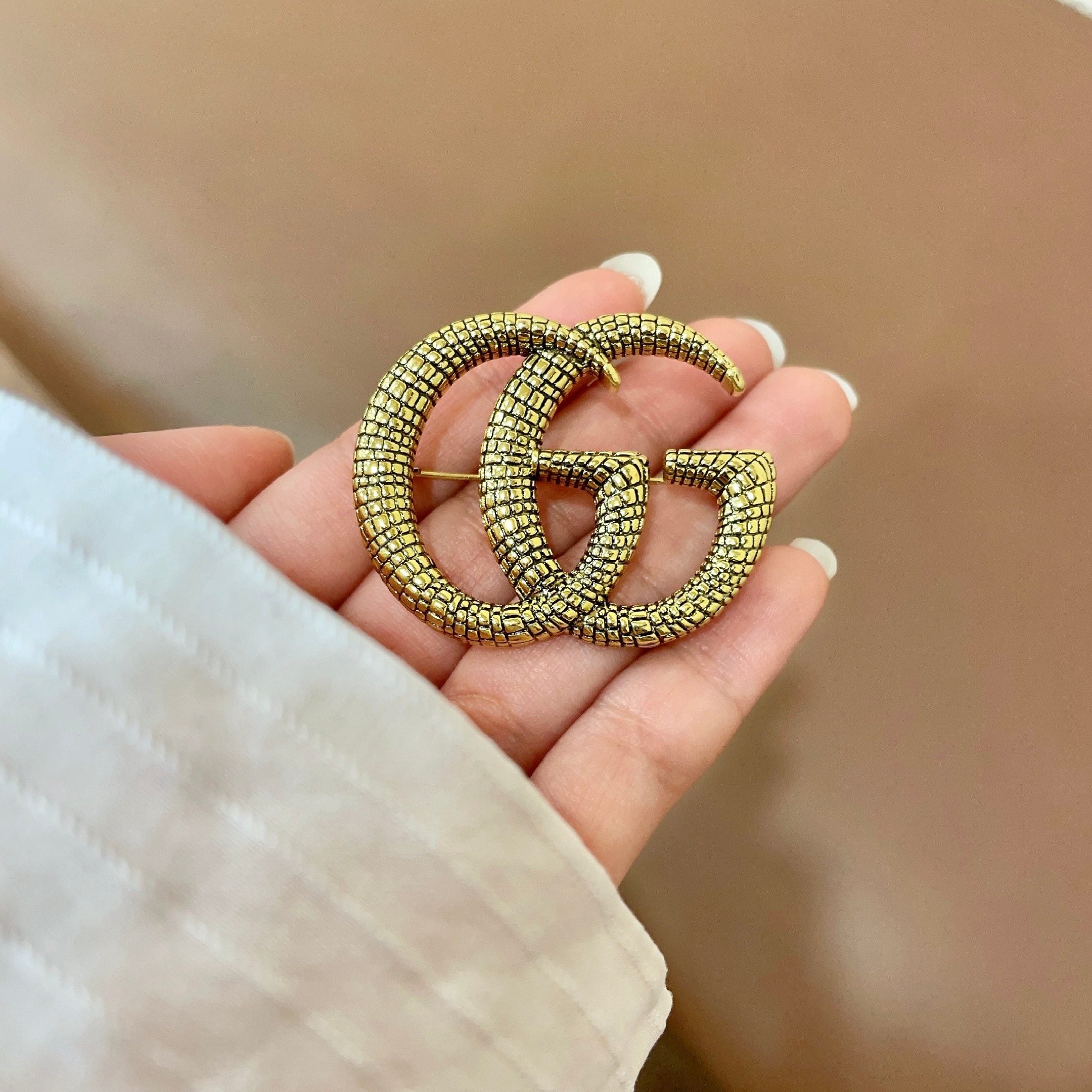 GUCCI 26S DOUBLE G LOGO TEXTURED STATEMENT BROOCH IN AGED GOLD TONE METAL 629062
