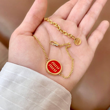 MIUMIU 26S LOGO ROUND BRACELET IN RED ENAMEL AND GOLD TONE METAL 631810