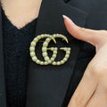 GUCCI 26S DOUBLE G LOGO PEARL EMBELLISHED STATEMENT BROOCH IN GOLD TONE METAL 631921