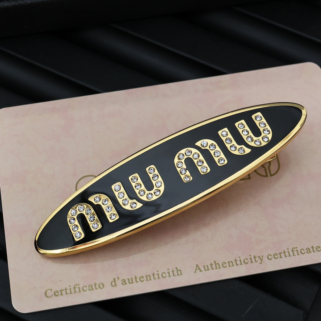 MIUMIU 26S CRYSTAL LOGO HAIR CLIP IN BLACK ENAMEL AND GOLD TONE METAL 626894