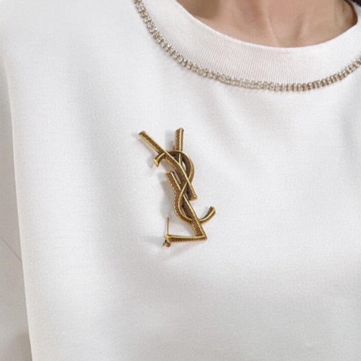 YSL 26S TEXTURED MONOGRAM BROOCH IN ANTIQUE GOLD TONE METAL