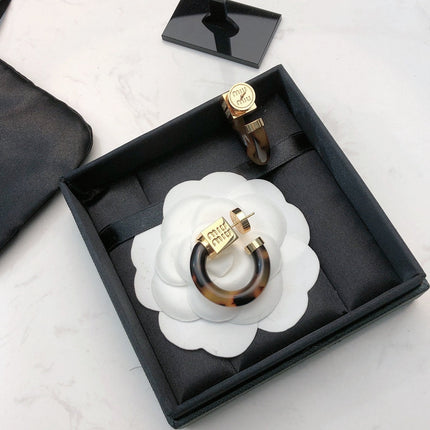 MIUMIU 26S TORTOISESHELL RESIN CURVED HOOP LOGO EARRINGS IN GOLD TONE METAL 615773