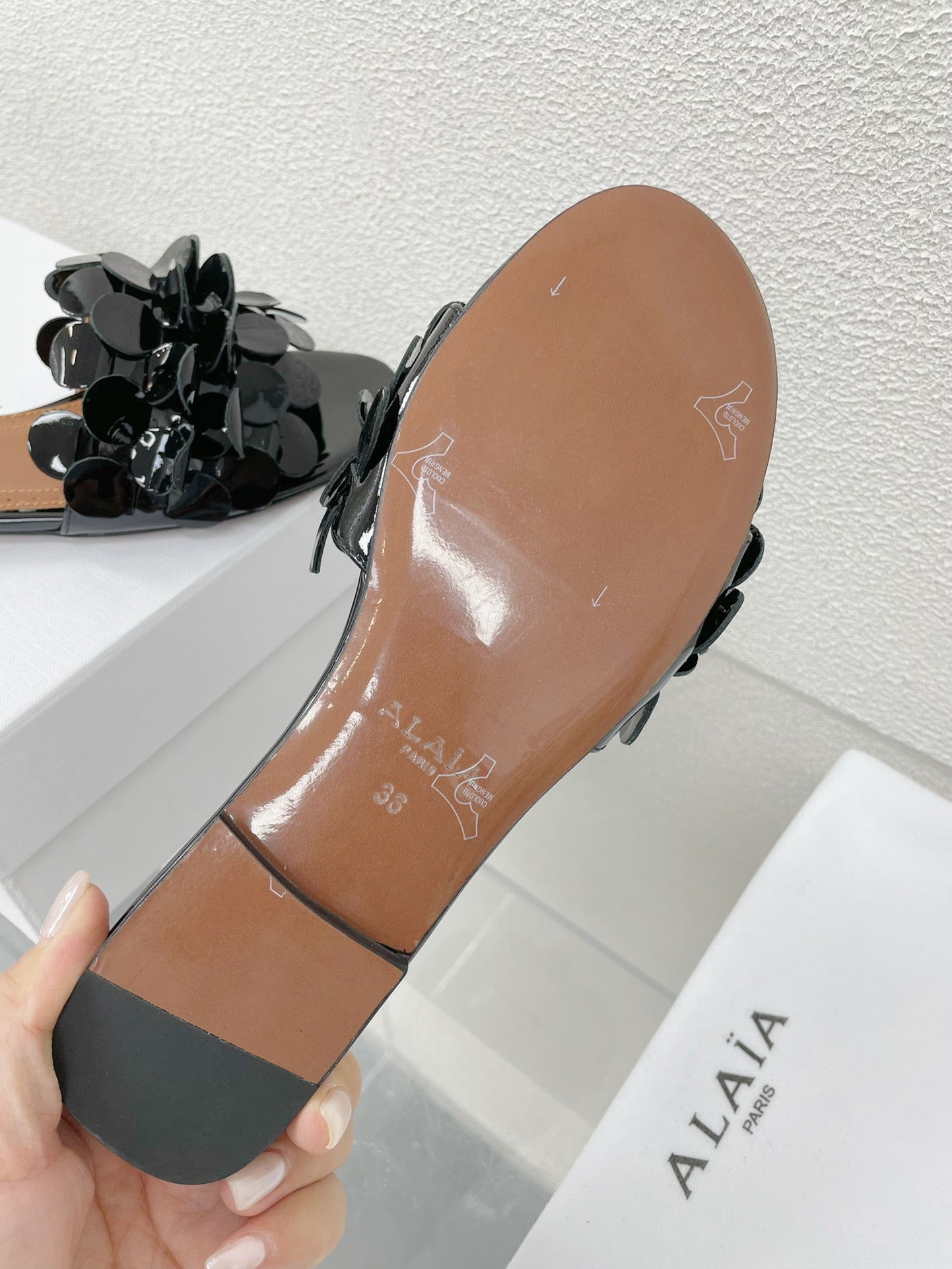 ALAIA FLAT MULE IN BLACK GLOSSY LAMBSKIN