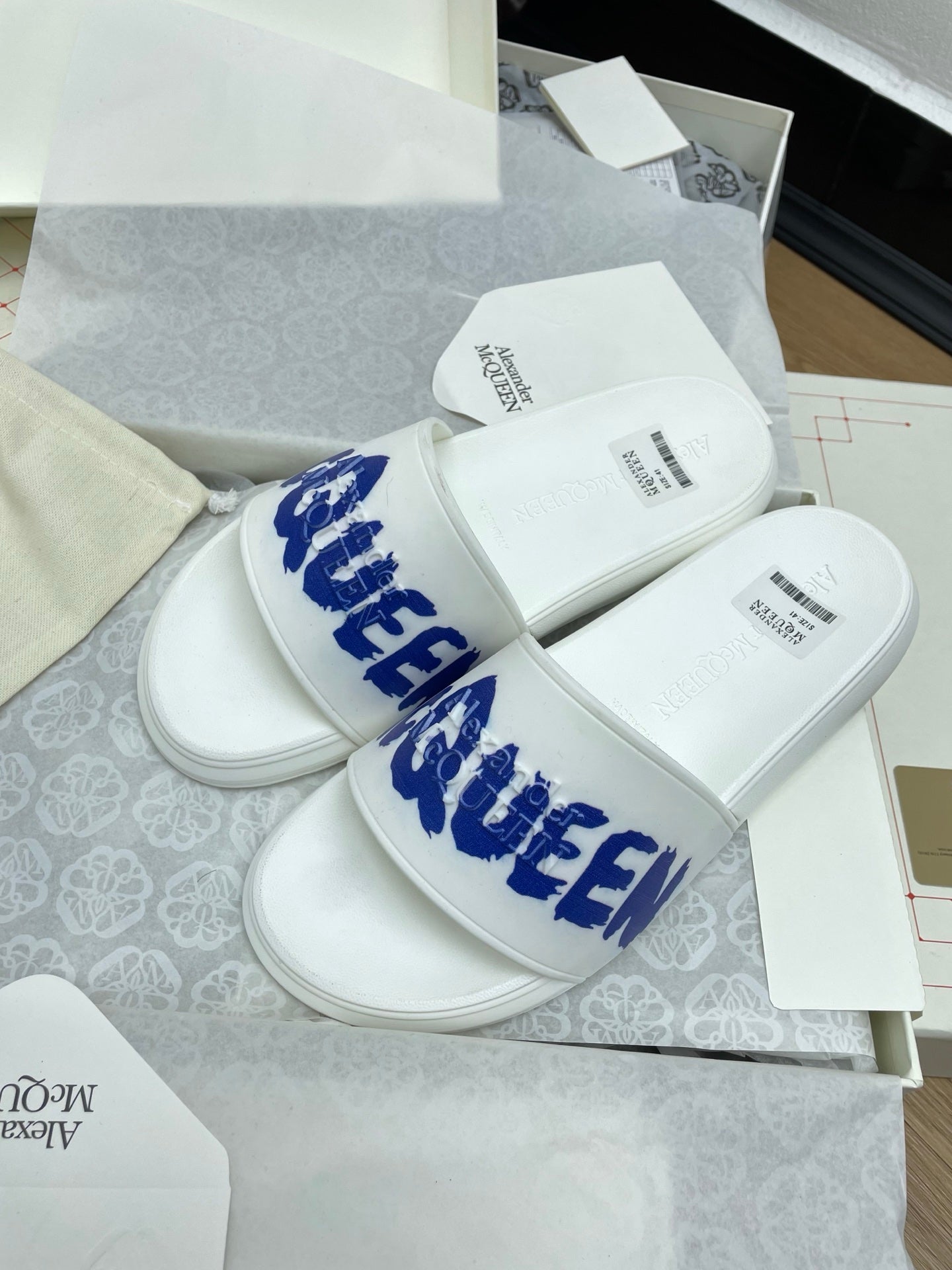 SLIDES SANDAL IN WHITE WITH BLUE LOGO GRAPHIC IN STRAP