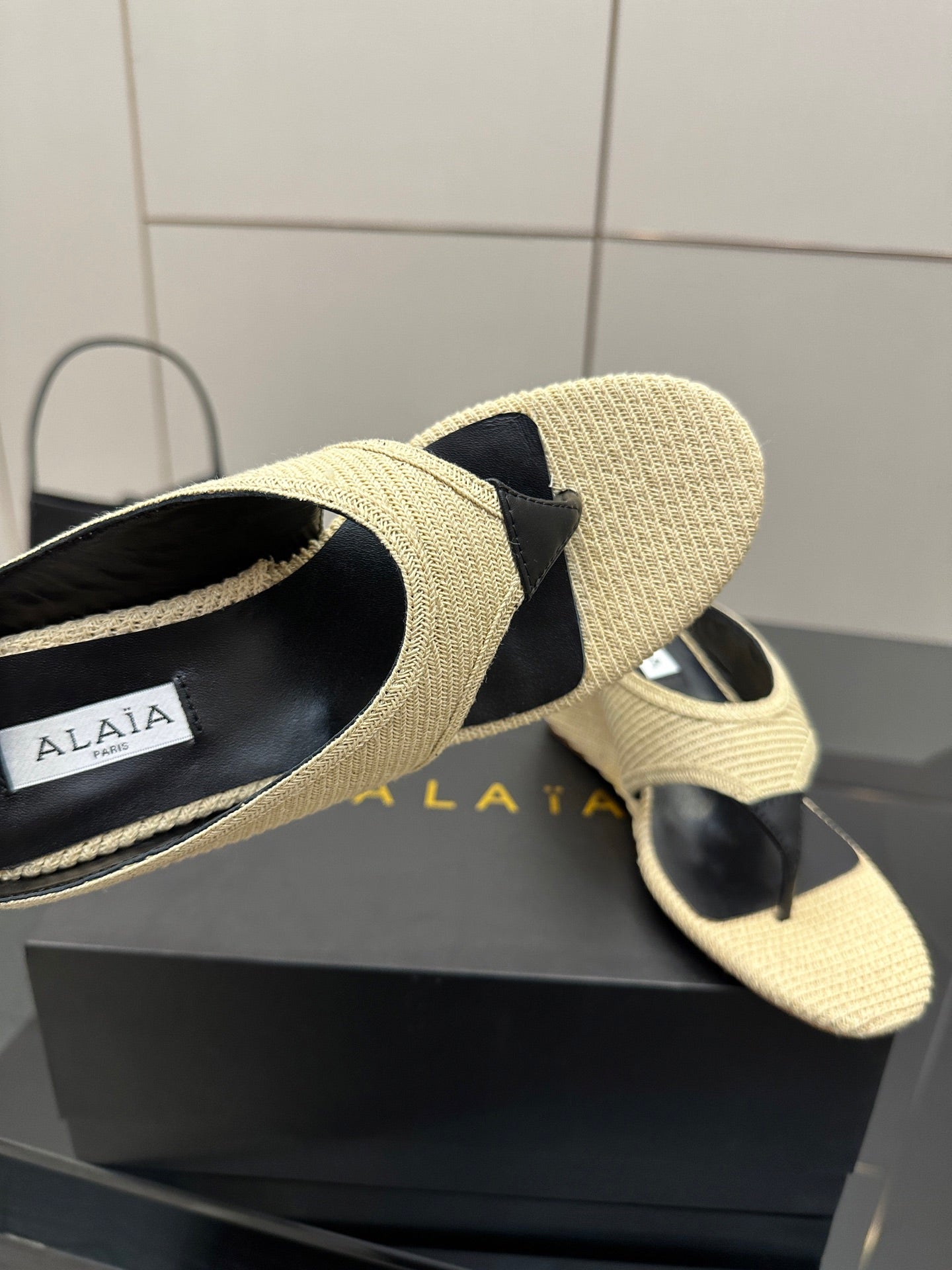 ALAIA WEDGE THONG SANDALS 25S IN LIGHT BEIGE RAFFIA