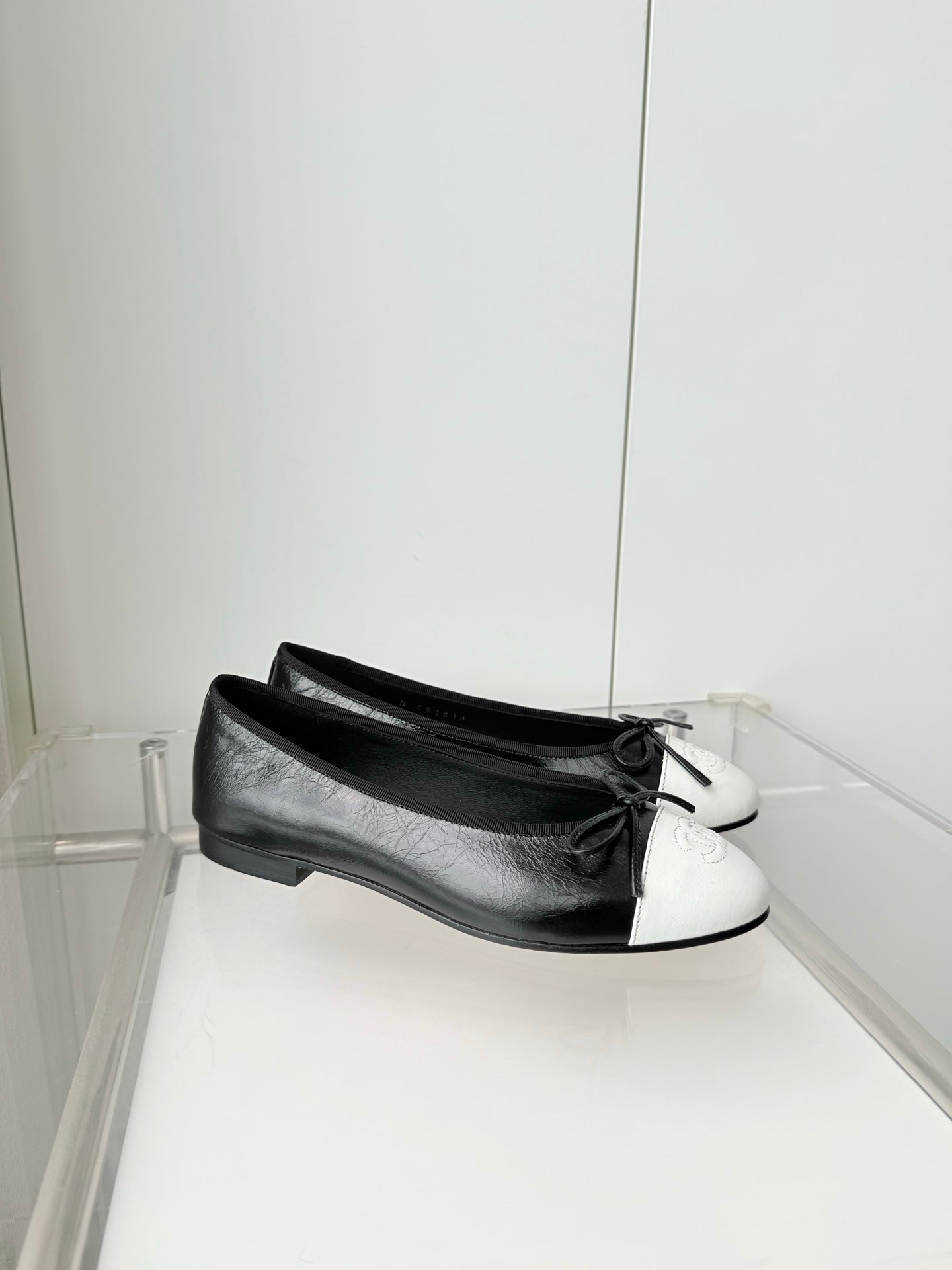 CHANEL 26S BALLET FLATS IN BLACK CRACKED CALFSKIN WITH WHITE TOE CAP AND BOW